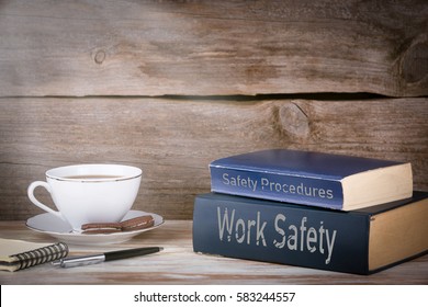 Work Safety And Safety Procedures. Stack Of Books On Wooden Desk