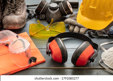 Work Safety Protection Equipment. Industrial Protective Gear On Wooden Table Background, Closeup View. Construction Site Health And Safety Concept