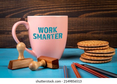 Work Smarter. Coffee mug with text on a blue office desk.