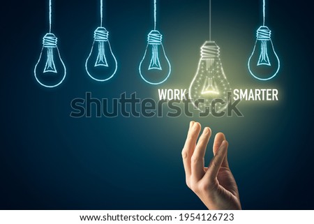 Work smarter concept with light bulb. Male hand pick light bulb (symbol of intelligence, creativity and innovation) which is lightened.