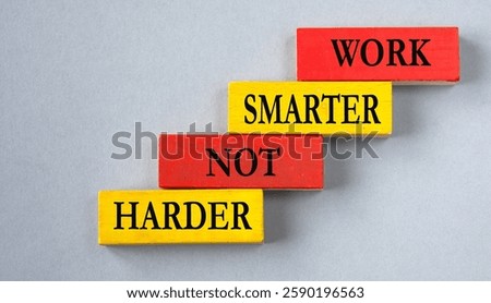 WORK SMARTER NOT HARDER - words on colorful wooden blocks on a grey background