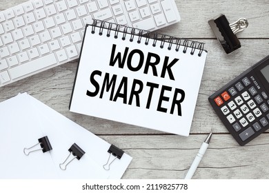 Work Smarter notepad with text on a white computer keyboard on a wooden background and other supplies