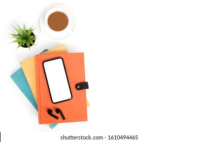 Work Space Back To School And Education Concept On White Modern Table Desk With Blank Screen Phone And Stack Of Book, Earphone, Green Plant And Coffee Cup, Flat Lay, Top View With Copy Space