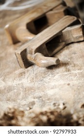 a work table of a carpenter with two hand planers and a pile of wood chips