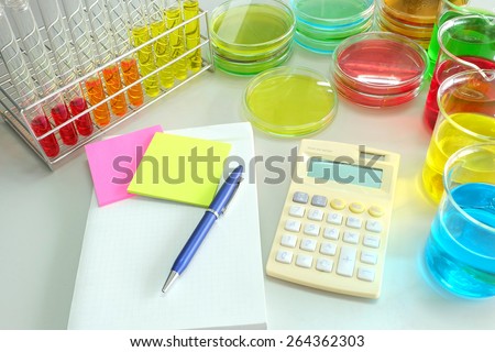 work table in laboratory and colorful fluid in glassware