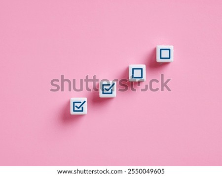 Work or task progression in project management. Completing tasks. White cubes showing increasing progress towards a goal, represented by checkmarks on a pink background.