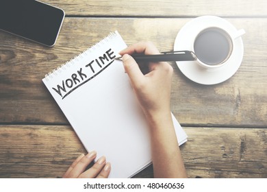 Work Time text on page and woman hand  pen on wooden table