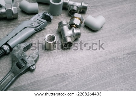 Work tools background. Plumbing concept set of piping accessories plumb adjustable wrenches fittings on wooden background. Plumbing tools and equipment on table with copy space