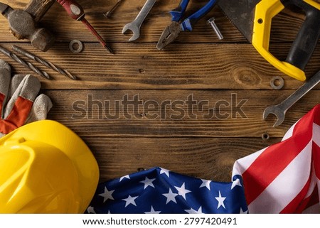 Work tools and a hard hat arranged with an American flag to evoke Labor Day in the USA, symbolizing construction, industry and patriotic pride