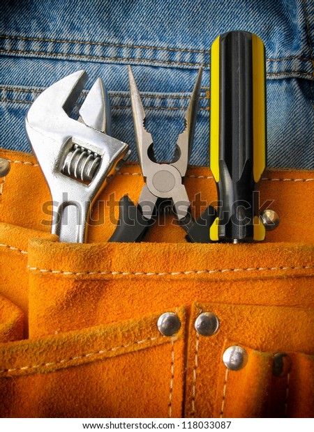 Work tools in orange\
tool bag with jeans.
