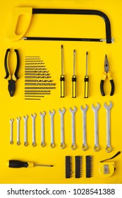Work tools organized on yellow background. Knolling concept