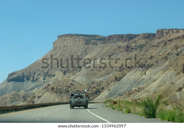 Work truck heading down the highway in\
Southeastern Utah. Driving into the\
bluffs.