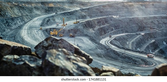 Trabajos de camiones y excavadora en una mina de oro abierta, foco suave