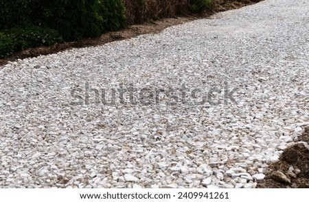 Work is underway to build and lay a new road. Gravel of large fractions Crushed stone building aggregate stone structure. Crushed Stone close-up Lies on ground. Breakstone. Focus on center photo