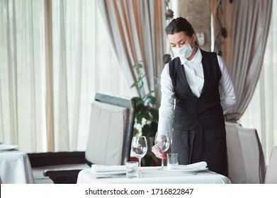 work of a waiter in a restaurant in a medical mask