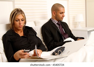 Workaholic Couple Working In Their Bedroom