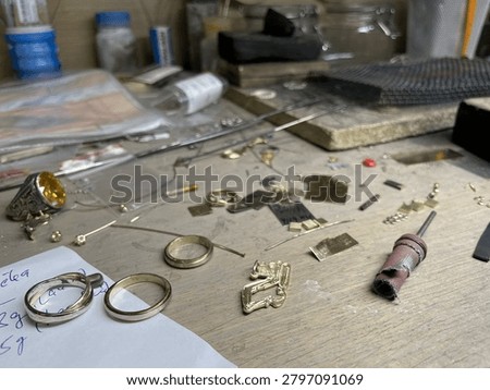Workbench in a goldsmith's workshop with jewelry, tools and implements