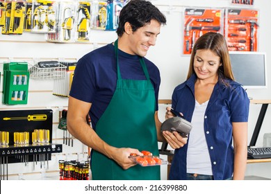 Worker Accepting Payment Through Smartphone From Woman In Hardware Store