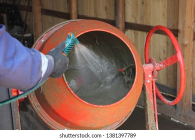 Worker Adds Water To The Red Cement Mixer