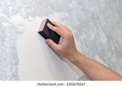 Worker Aligns The Sandpaper Wall