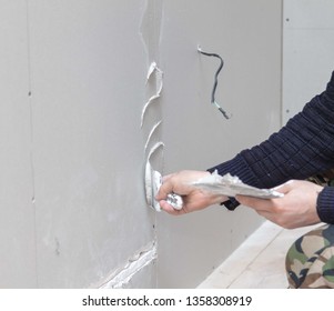 Worker aligns the walls with plaster. Repair in the house.