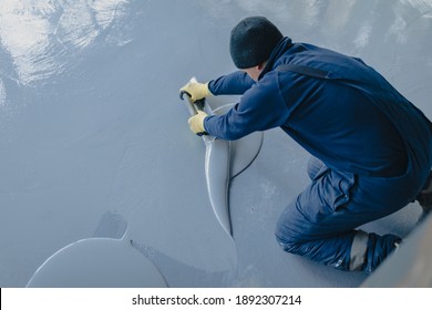 The Worker Applies Gray Epoxy Resin To The New Floor