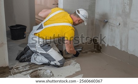 A worker applies a liquid membrane on the bathroom floor. Foolproof waterproofing under a tile bathroom.