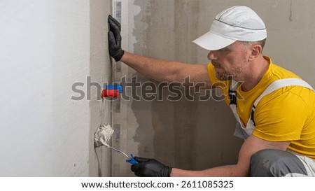 A worker applies a liquid membrane using a paint roller. Foolproof waterproofing under a tile in shower cubicle.