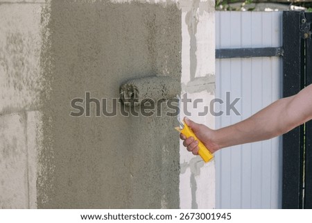 Worker Applying Plaster with Roller.
