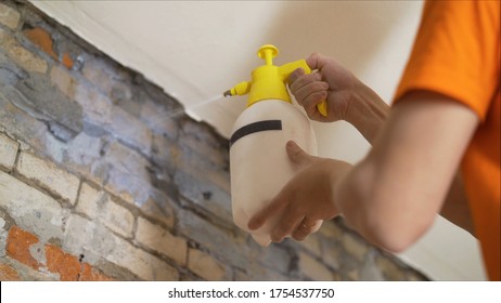 A Worker Is Applying A Primer To A Brick Wall. Applying A Primer Using A Sicator. Applying A Primer On The Wall Using A Spray Gun. A Construction Worker Uses A Spray Gun To Apply A Primer To A Brick