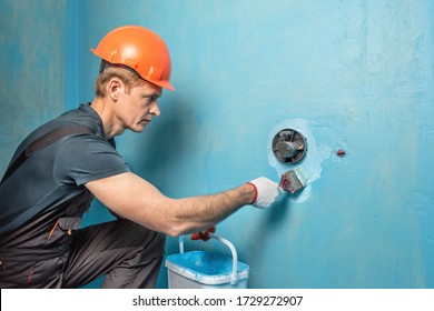 The Worker Is Applying Waterproofing Paint To The Wall In The Bathroom. 