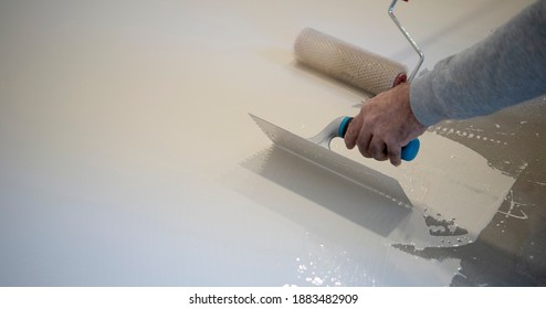 Worker Applying A White Epoxy Resin Bucket On Floor
