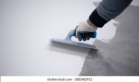 Worker Applying A White Epoxy Resin Bucket On Floor
