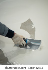 Worker Applying A White Epoxy Resin Bucket On Floor