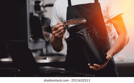 Worker in apron packs roasted coffee in vacuum bag on roasty factory coffeeshop - Powered by Shutterstock