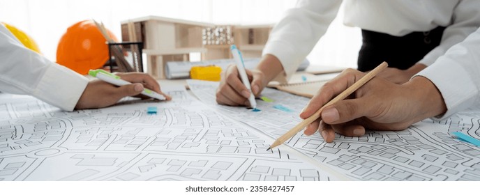 Worker, architect and engineer work on real estate construction project oratory planning with cartography and cadastral map of urban town area to guide to construction developer business plan of city