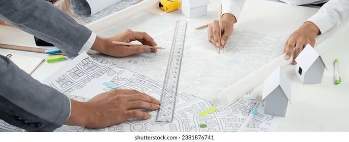 Worker, architect and engineer work on real estate construction project oratory planning with cartography and cadastral map of urban town area to guide to construction developer business plan of city