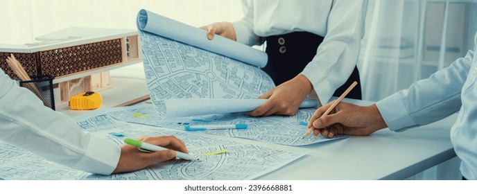 Worker, architect and engineer work on real estate construction project oratory planning with cartography and cadastral map of urban town area to guide to construction developer business plan of city