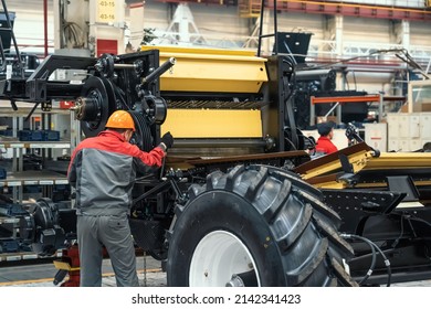 Worker assembles agricultural vehicle combine harvester in industrial factory workshop - Shutterstock ID 2142341423