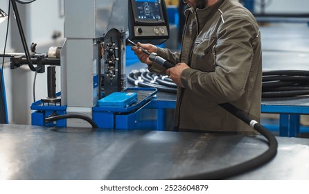 Worker assembles high pressure hose. High pressure hose production. - Powered by Shutterstock