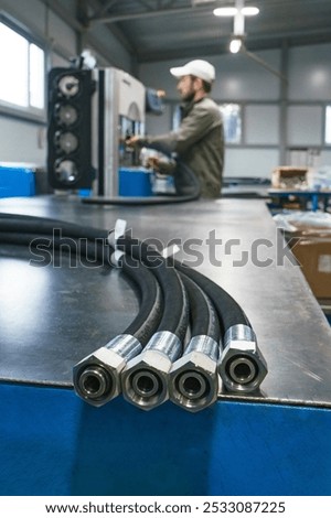 Worker assembles high pressure hose. High pressure hose production. Workplace. Factory.