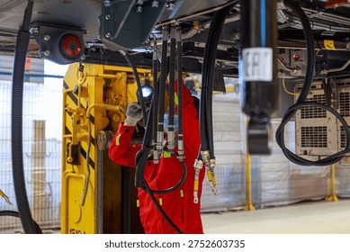 A worker assembles a subway car. Workshop of a transport engineering plant.