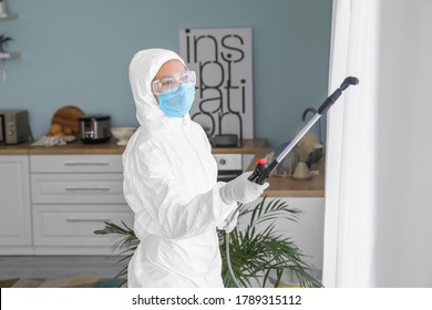 Worker In Biohazard Suit Disinfecting House