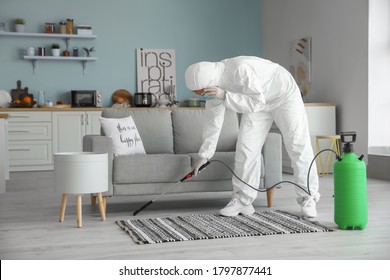 Worker In Biohazard Suit Disinfecting House