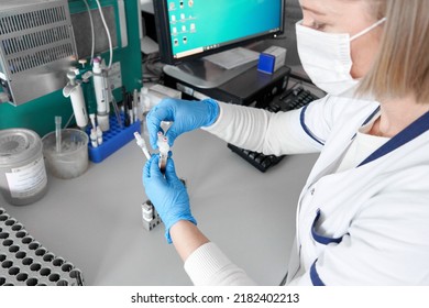 Worker With Blood Samples Next To A Centrifuge Reaction Vessel