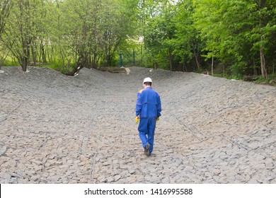 Worker In Blue Uniform, Leaving The Construction Of Fortified Shores, Rear View