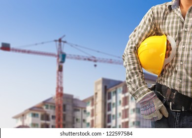 Worker And The Blurred Construction Background In Blue Sky