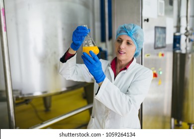 Worker at bottling factory checking juice quality. Selective focus on hand. - Powered by Shutterstock