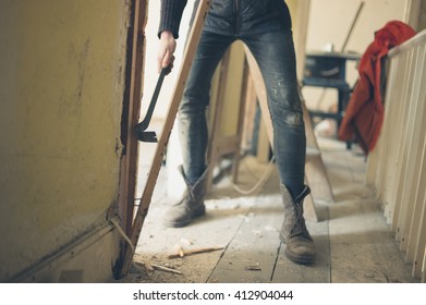 A Worker Is Breaking Down A Door Frame With A Crowbar