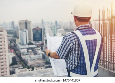 The worker builder foreman engineering occupation working with construction site project background. person looking plan paper to made floor business tower building. industry achitecture building.